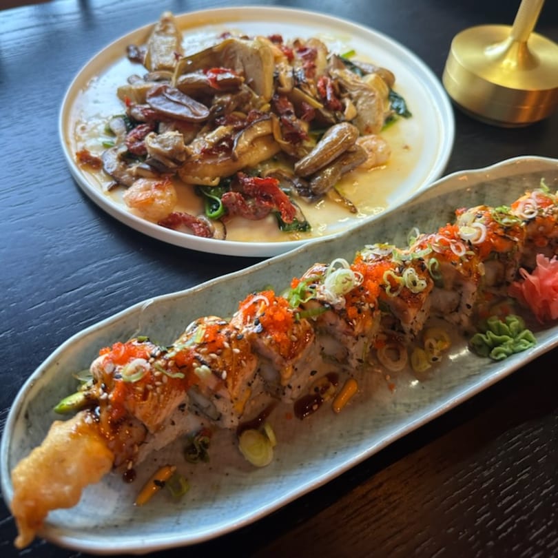 Rio of Japan sushi roll with red roe, scallions, and a side dish of mushrooms and shrimp.